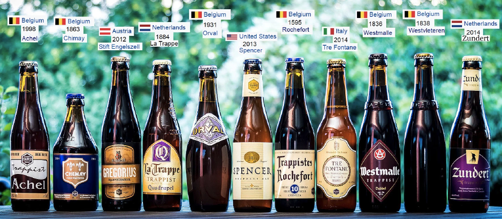 11 bières trappistes alignées sur une table.